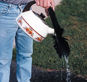 Cleaning a broom with hot water