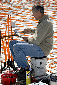 Bob &ldquo;Hot Rod&rdquo; Rohr installs radiant heat equipment on an under-concrete job in Branson, Mo.
