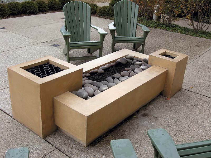 Rectangular stepped fire pit with river rock.