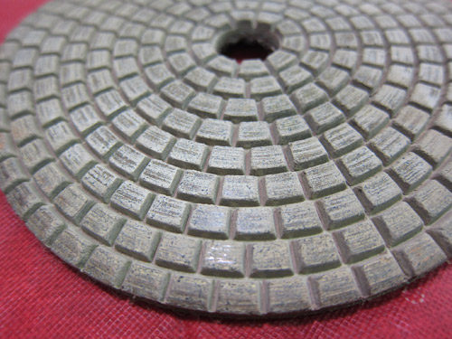 A dry polishing pad with a resin binder. Inexpensive pads can use soft resin binders that wear quickly. Buying a more expensive, higher-quality pad can save you money in the long run versus buying multiple cheaper pads.