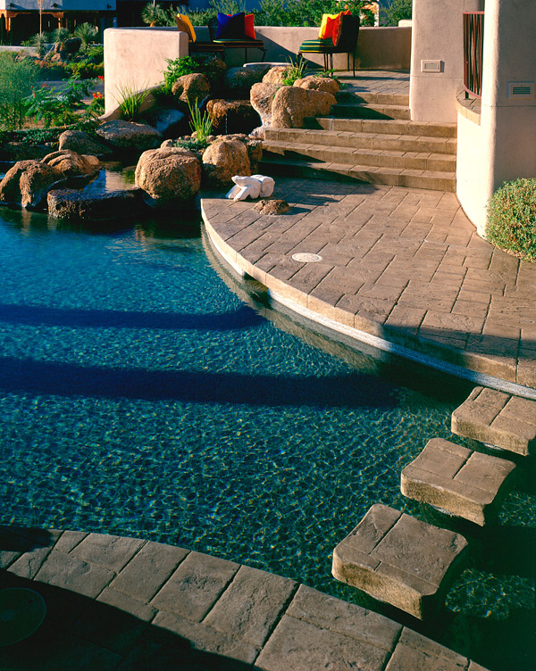 stamped concrete deck with gorgeous pool and rock features