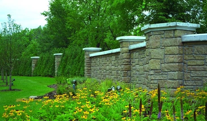 Tranquil garden with black eyed susans flowers protected by a concrete wall that looks like stone from the use of form liners.