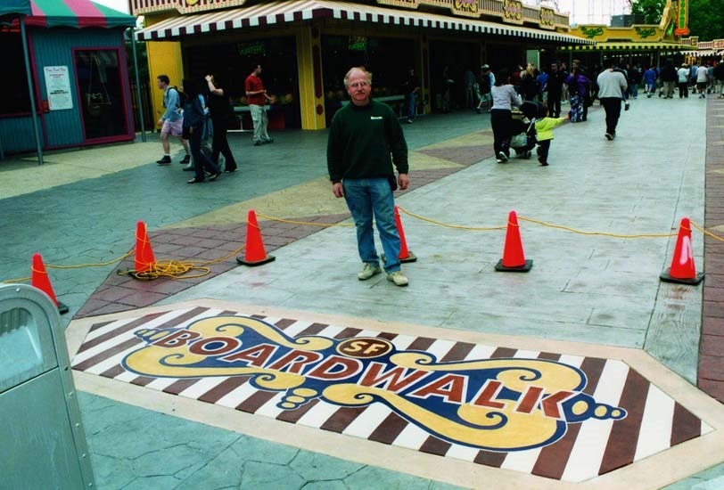 Bomanite contractor Ira Goldberg proudly stands in front of San Francisco boardwalk logo made with Bomanite materials.