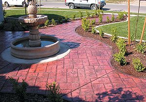 curved stamped walkway - Planter beds are used to protect sealer from lawn sprinklers.