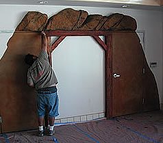 Final staining touches to a vertically carved concrete mine shaft entranced in a mini market in Southern California.