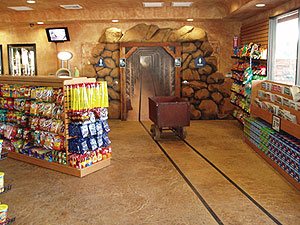 Mine shaft entrance in a mini market in southern California features stained and vertically carved concrete boulders.