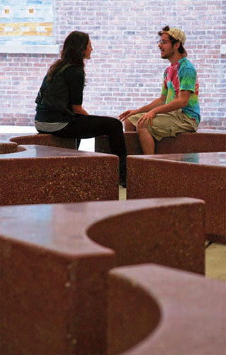 Two students sit on the concrete benches.