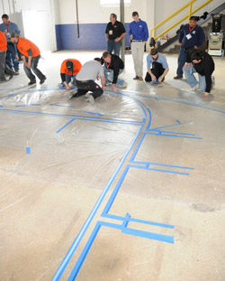 Attendees install the tape line for the polished concrete training class.