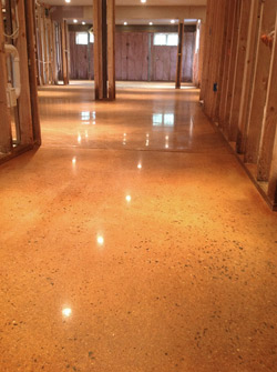 The color-troubled polished concrete floor in a residential basement, before a four-step process fixed the problem. The same floor  problem solved