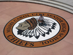 Engraved concrete of a school mascot in a concrete overlay stained in rich browns and black