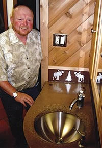 John Cox of Cox Decorative Concrete, John Cox of Cox Decorative Concrete. apricot-colored bathroom sink top that features a curved outer edge and tapered basin lip. The edge and basin lip were finished without a slurry mix, giving them a rougher look than the concrete countertop. 