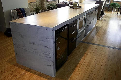 Kitchen Concrete Countertop from Specialized Construction Services with a waterfall edge. Looks like marble.