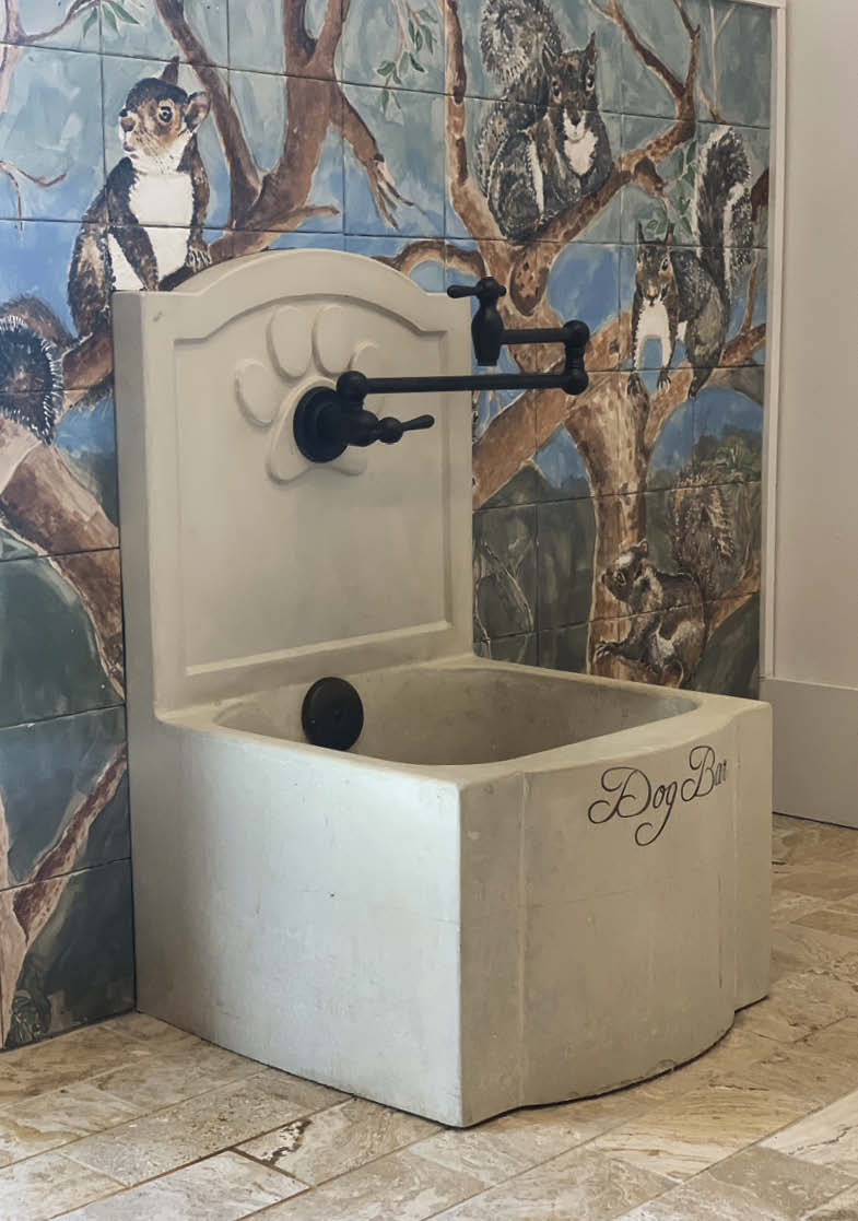 Concrete washbasin up against as tree mural.