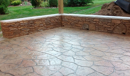 Stamped concrete patio with sitting wall.