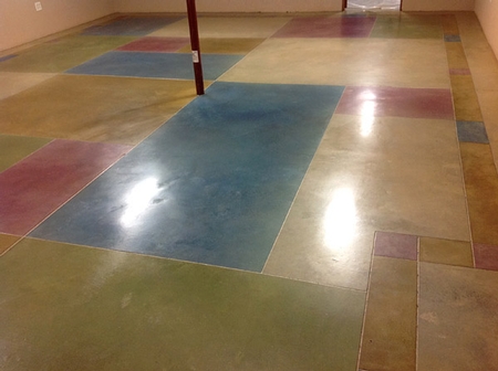 Dyed concrete floor with multiple color blocks in reds, greens blues and tans.