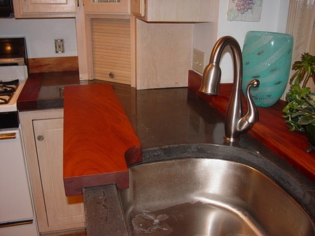 dark gray concrete countertop with a stainless steel sink in the kitchen
