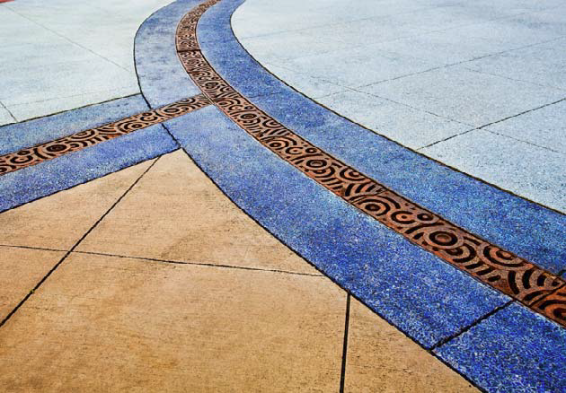 Use of decorative drains takes an otherwise simple stained concrete patio to the next level.