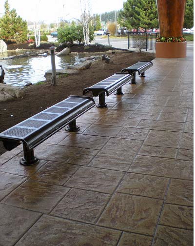 Stamped and stained concrete with benches makes for an appealing waiting area in a park setting.
