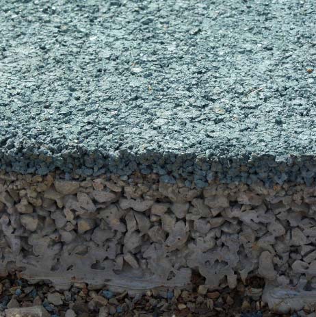 Much of the pervious concrete placed for the Olympics consists of a top layer of integrally colored premium aggregate mix on a coarser blend of aggregates and cement. The two layers combined are about 9 inches deep.