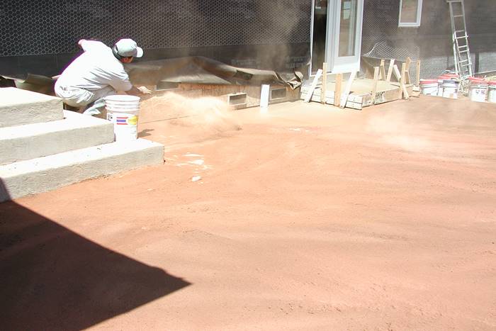 Throwing Color Hardener onto concrete for a non gray looking concrete slab.