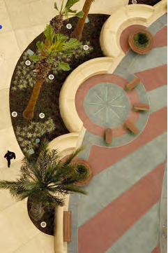 Aerial view of a concrete patio that has palm trees planted in the planter built at the edge.
