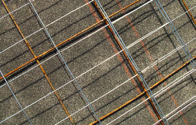 Typical welded wire fabric  a tight grid of galvanized utility fencing, with the roll of fencing material tied to the flat sheets of welded wire.