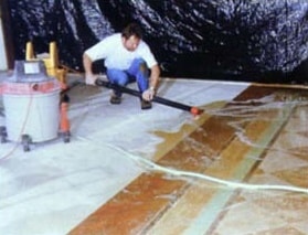 Step 3 of the basics of concrete overlays: Removal of excess concrete stain prior to neutralizing the concrete overlay.
