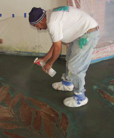 A crew member applies green and blue acid stains after the seaweed imprints have been stained and seale
