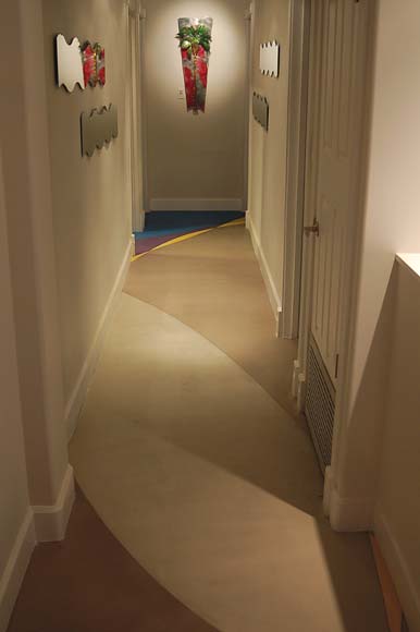 Concrete overlay in a hallway with sweeping colored patterns.