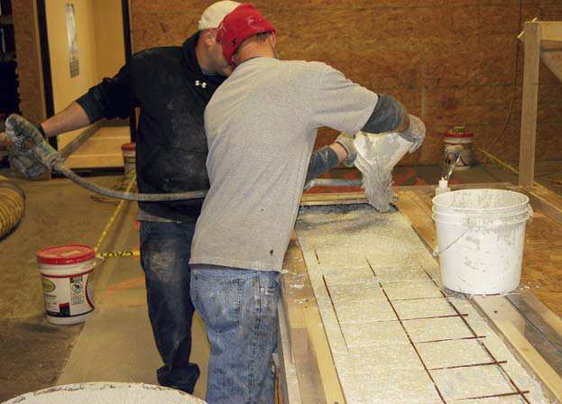Jason Geiser and team member create the forms and fill them with concrete for the skateboard steps.