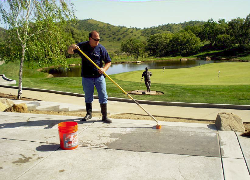 Glen Roman applies an acid wash over the freshly placed concrete.