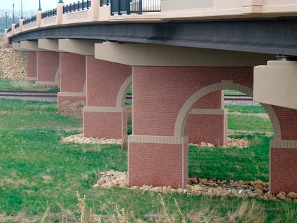 This bridge, which carries 195th Street across the Canadian Pacific Railroad tracks in Farmington, Minn., is supported by poured-in-place, arched concrete piers with integrally cast thin brick and simulated stone rustications.
