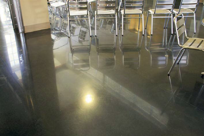 Break room that has chairs lined throughout has gray polished concrete floors.