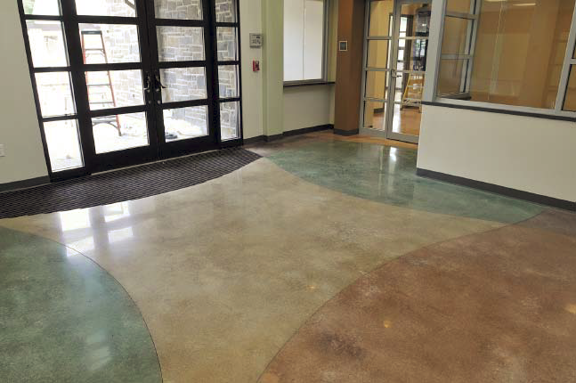 Concrete floor in a lobby has four distinct areas that are stained with different colors.