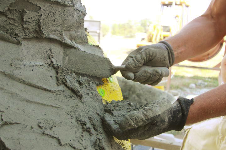 A person uses a carving trowel to carve and place concrete