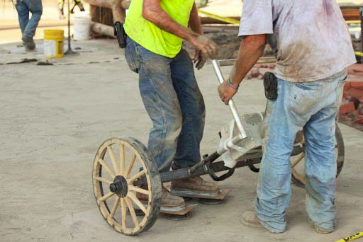 Two crew members work on equipment that helps give the look of the old west.