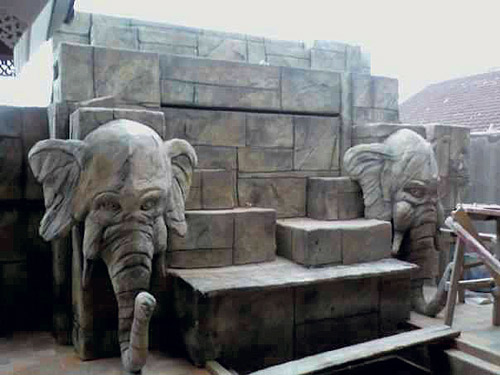 Two elephant heads flank this block wall made of concrete by Thom Hunt.