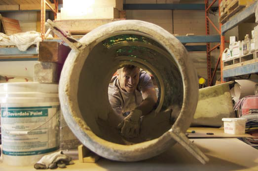 The artisan peering through a concrete tube during his work.