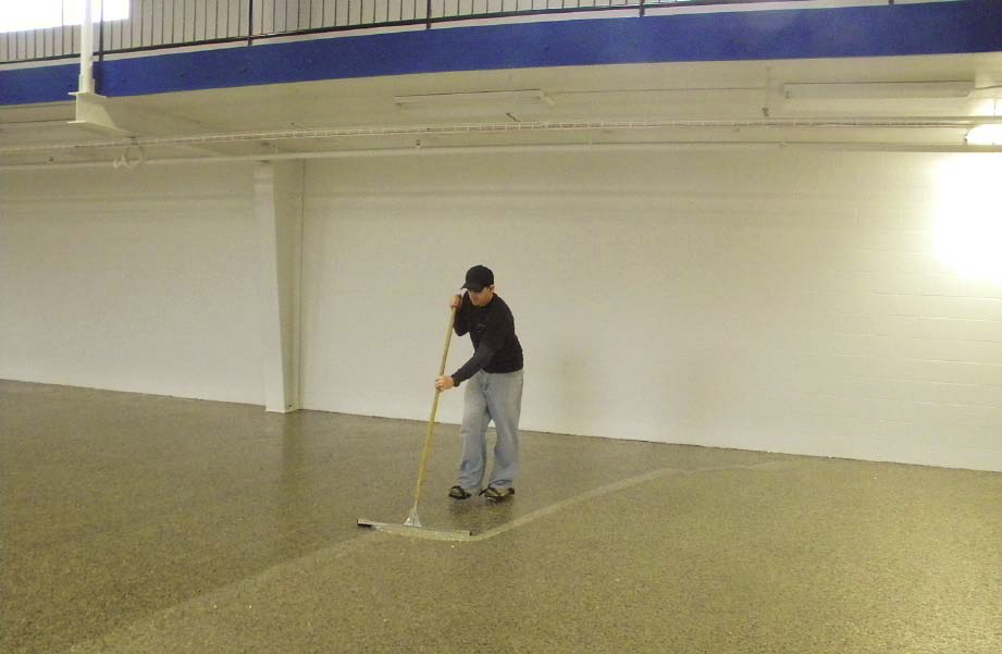 Crew members for Nashville-based Fuller Industries Inc. install a mica chip floor with roller brushes at a Nashville book and CD store using mica chips from Torginol and Florock polymers.