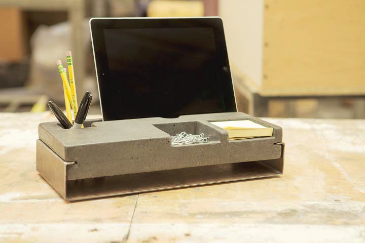 A concrete desk organizer that has a tablet holder.