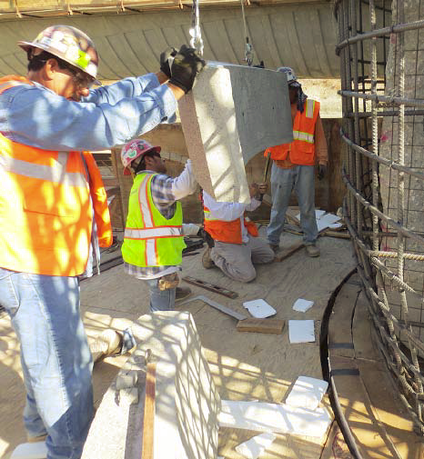 Construction workers placing the pieces of the concrete basket.