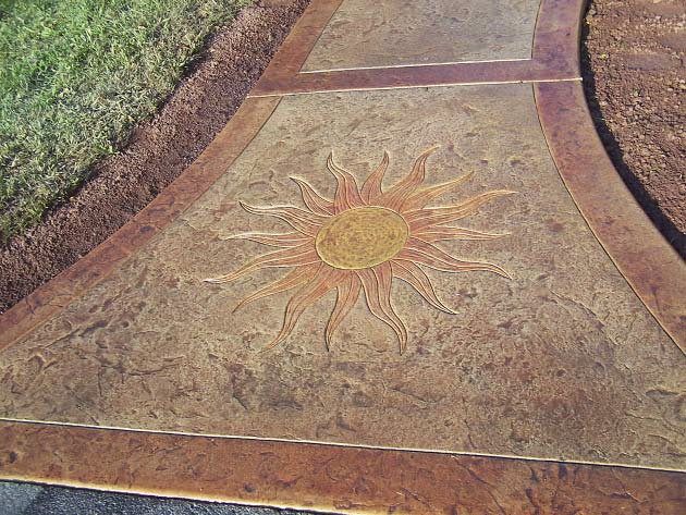 Stamped concrete sun pattern on the end of a concrete walkway.