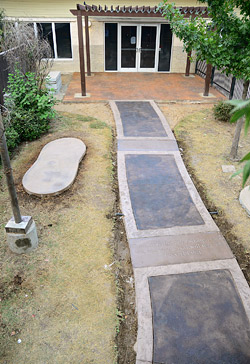 The courtyards existing 30-by-20-foot patio and 50-by-3-foot walkway were torn out and completely replaced with stamped and colored concrete about the same size or slightly larger. The new walkway included three engraved Bible verses.