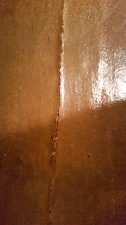 Cracks in concrete subfloor migrate to overlay