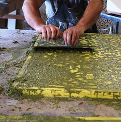 Squeegee being used to push GFRC into lattice concrete mold.