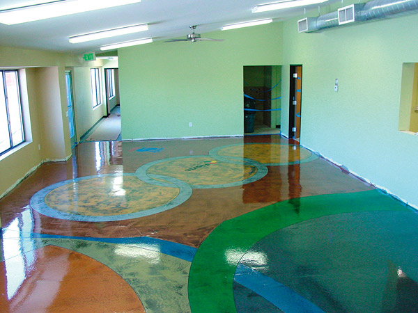 Concrete contractors use stains or dyes to color on a concrete floor adding delightful abstract artwork.