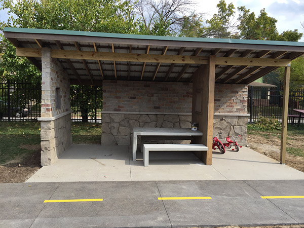 concrete bench and table featured inside rock picnic shelter