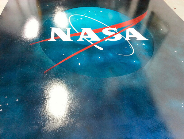 stenciled NASA logo on cloudy blue floor