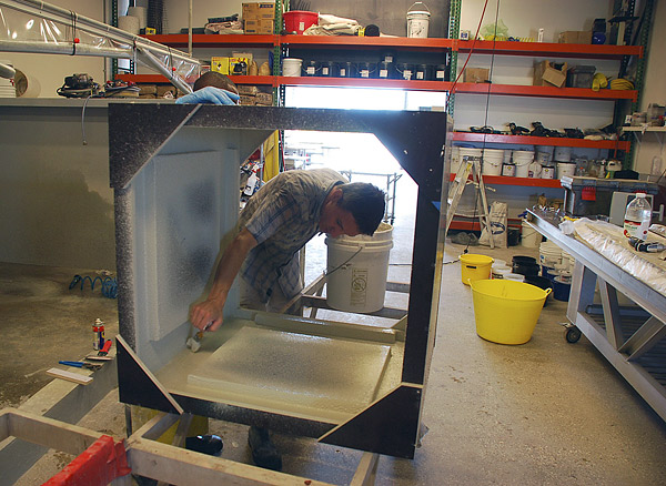 GFRC concrete expert applies a mist coat of GFRC to a table base mold.