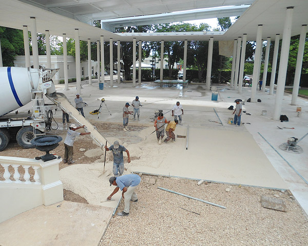Concrete construction workers manufacturing a white cement covered area in Mexico Museum.